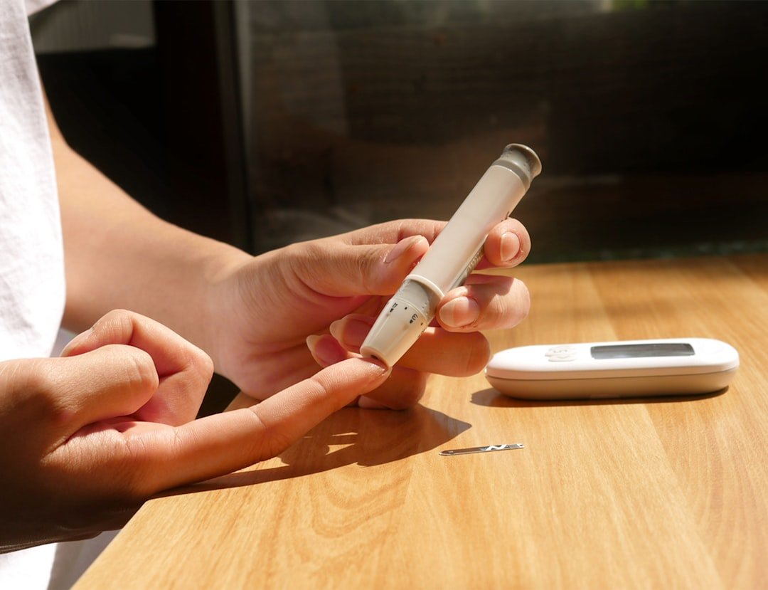 A person checking their blood sugar levels with a glucose meter, surrounded by healthy food options and a planner.