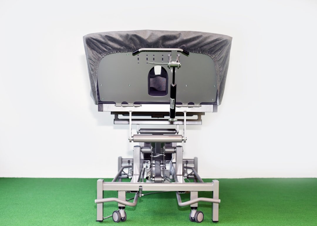 A caregiver assisting a patient in transferring from a bed to a chair, demonstrating safe lifting techniques and proper equipment use.