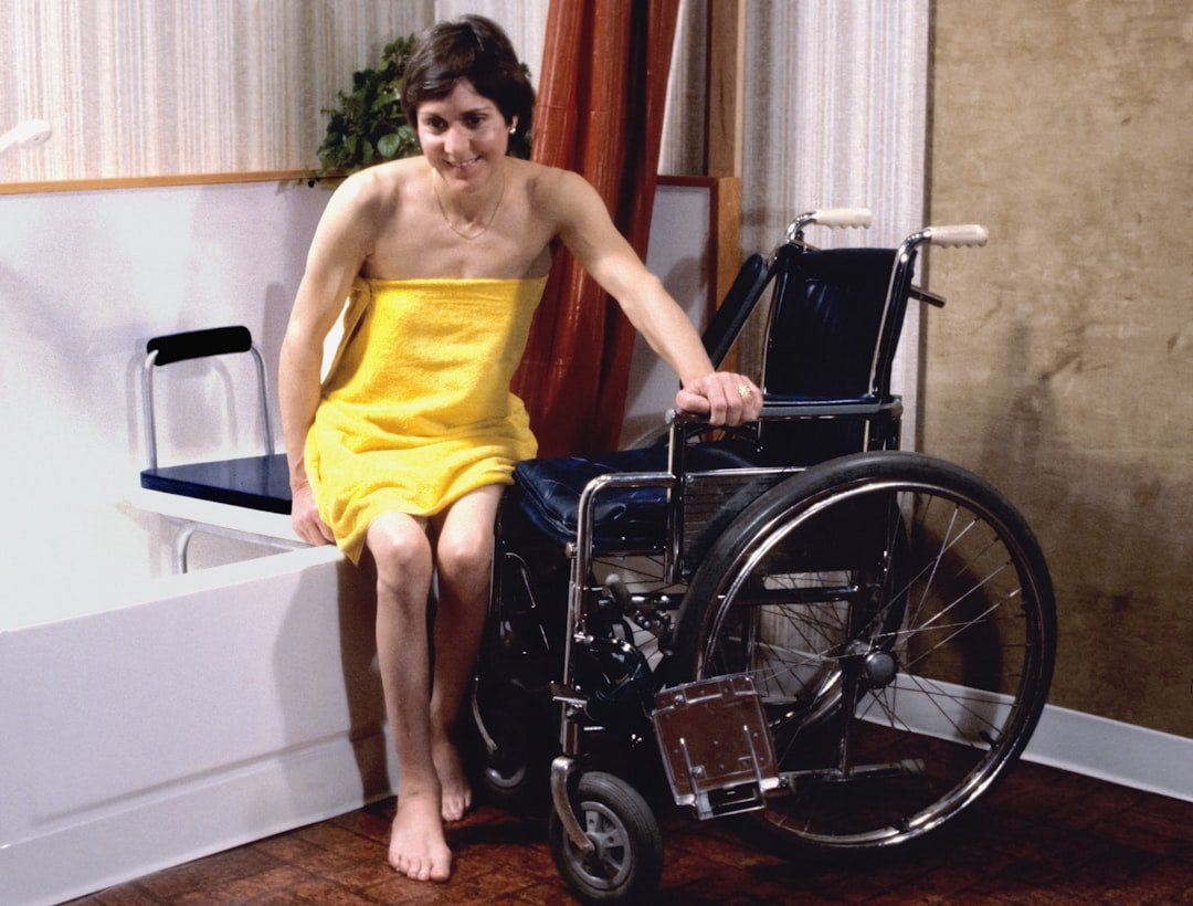 A person using a shower chair in a bright, accessible bathroom, showcasing comfort and safety.